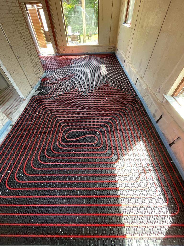 3 · Pipe pressed in — The heating pipe pressed between the studs, circuit by circuit — ready for the screed.